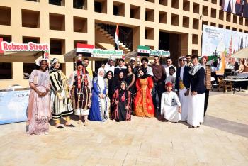 A group of students in various cultural dresses pose for a photo