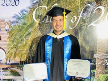 Graduate student EzzEldien Yousef holding his certificate and award at the 2026 commencement