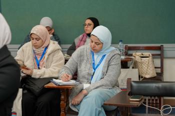 two veiled female students sitting in a classroom