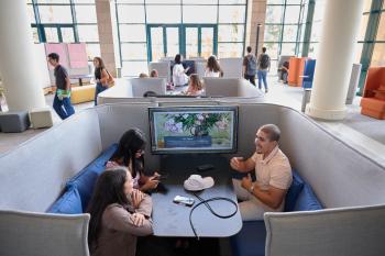 Three students sitting in a booth in the newly renovated library.