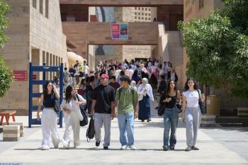 Students walk in a line on campus. 