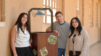 Three students stand in front of smart bin.