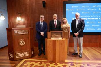Atef and Fofa Eltoukhy, Chairman of the Board Mark Turnage and AUC President Ahmad Dallal standing in front of a screen