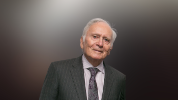 Arthur Lindenauer in a suit in front of a mixed light background