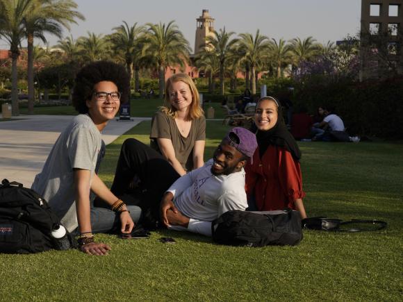 AUC international students sitting in the campus gardens. 