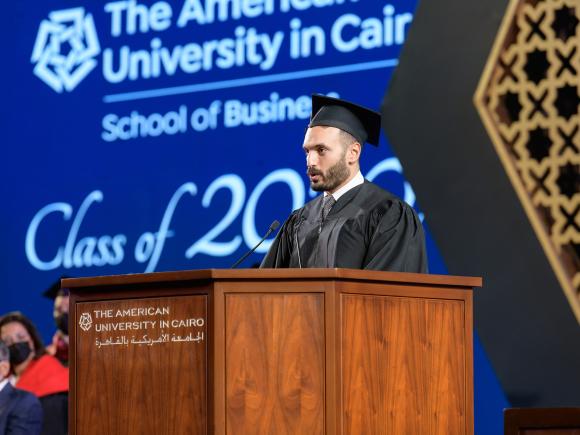 Graduating student standing on podium giving a speech