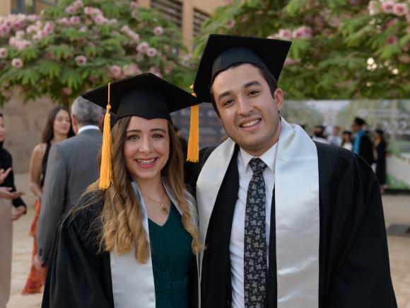 Boy and girl smiling with cap and gown