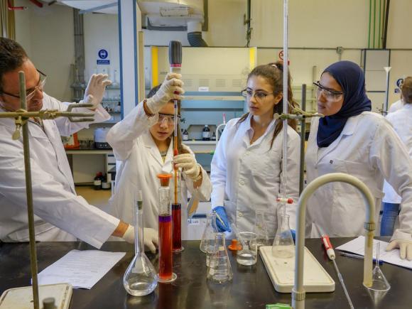 Female students in a lab with faculty