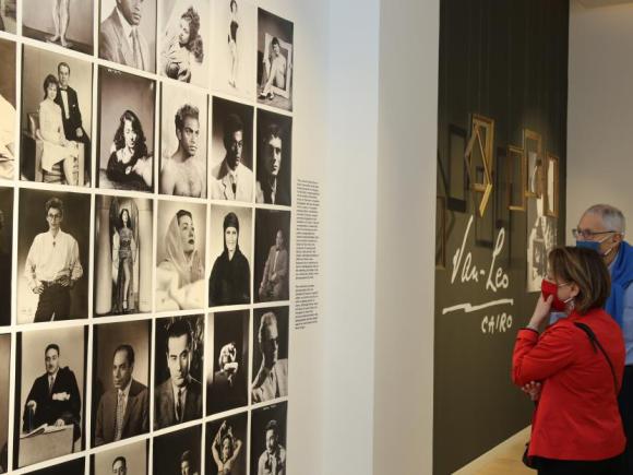 Lady and man looking at wall with art photos