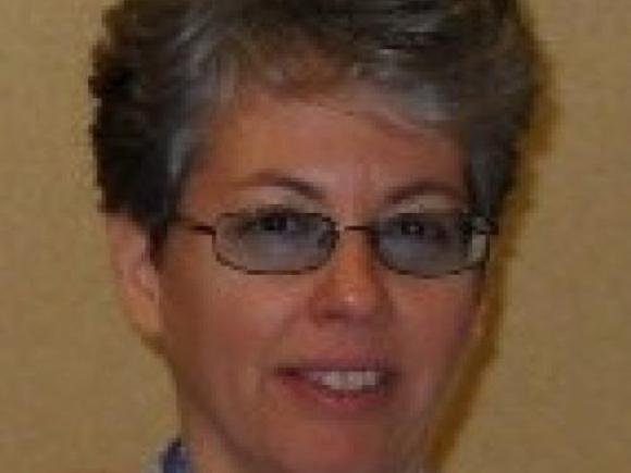Close up of a lady with grey hair and glasses