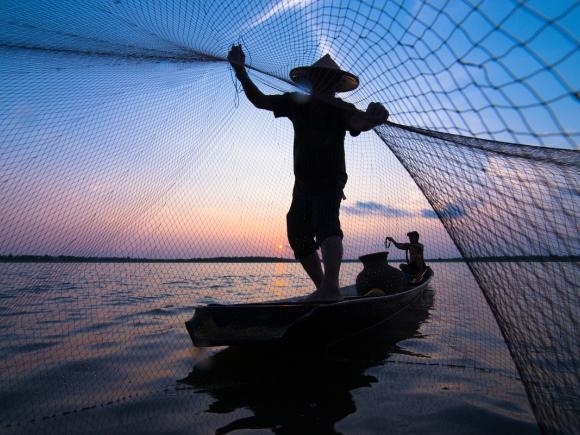 Man sailing and holding a fish net