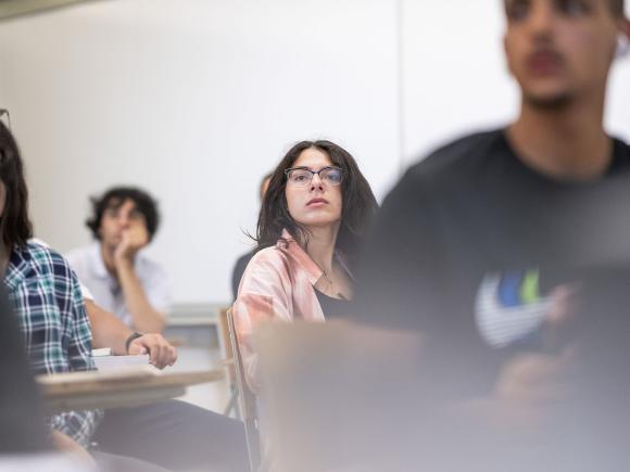 Girl wearing glasses in class concentrating 