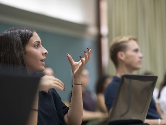 Girl in class talking with her laptop opened