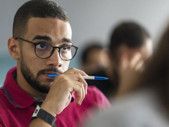 Boy in class wearing glasses and thinking