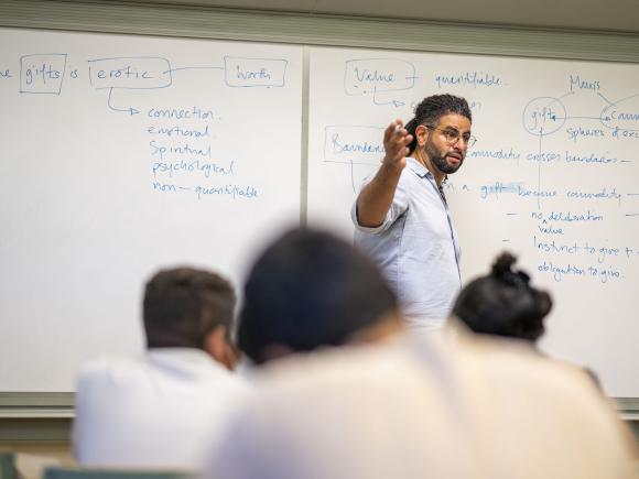 Instructor standing and talking to students in class