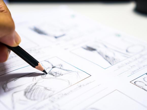 hand holding a pencil writing on a white paper
