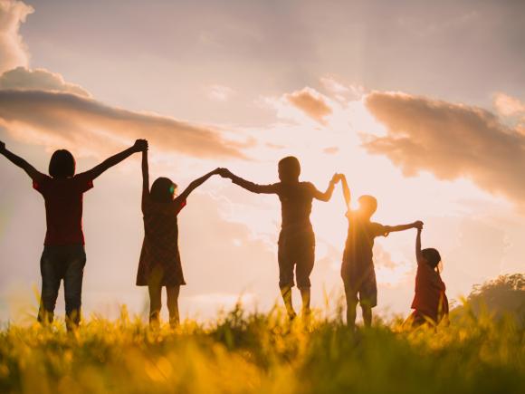 children holding hands in sunset