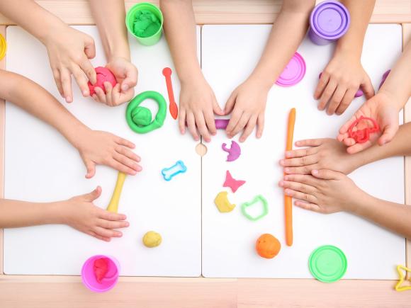 Hand of little kids playing with playdough