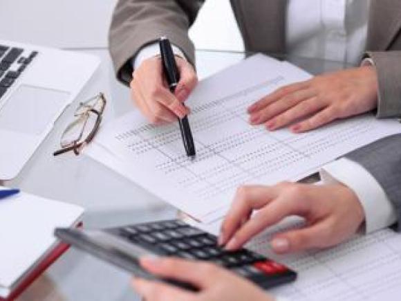 Man wearing a suit writing on a white paper