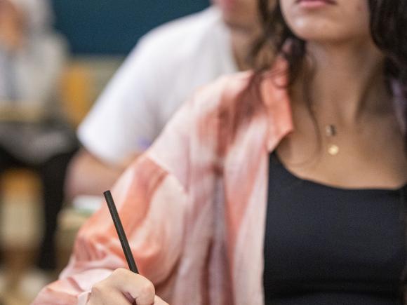 female student in classroom writing notes