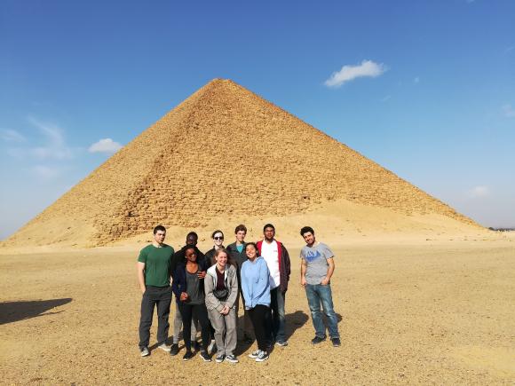 A group of girls and boys standing by the pyramids