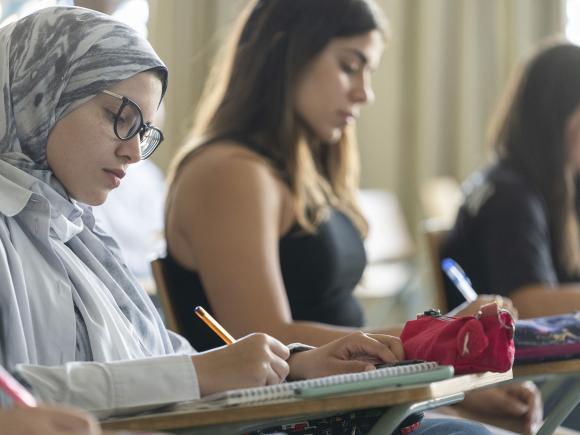 Political Science CEMPS program image of female students taking notes in class