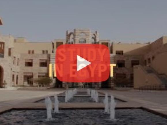 A water fountain in the middle of buildings, text reads "Study in Egypt"