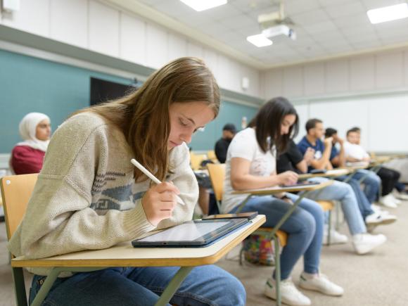 Students sitting in class writing