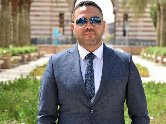 A man with a suit and tie in an outdoor setting