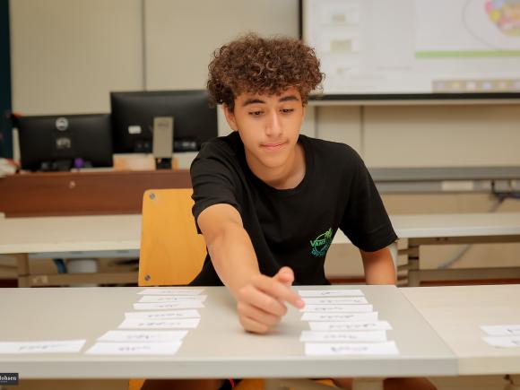 Student reading Arabic words from cards