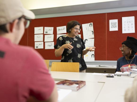 A woman with short hair talking to a student in a classroom