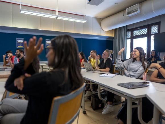 Students raising their hands in class