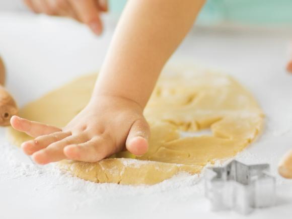a hand of a baby playing with a playdough