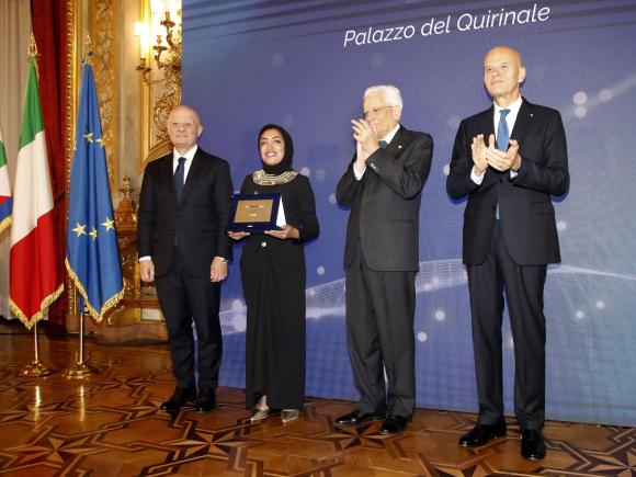 Shima Farag is standing between the President of Italy and the CEO of Eni Company