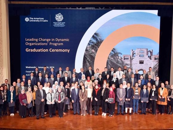 Graduating participants are standing at the stage of Bassily Auditorium 
