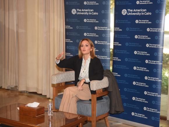 Professor Seham Elmrayed speaks in front of a step-and-repeat