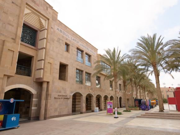 Abdul Latif Jameel campus building lined with palm trees.