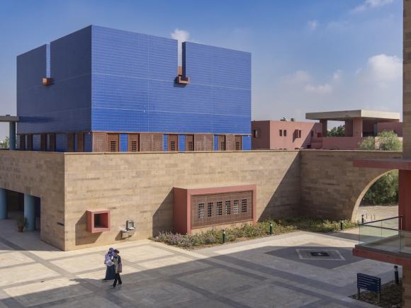 Moataz Al Alfi Hall at AUC with its distinctive blue exterior panels overlooking a campus courtyard.