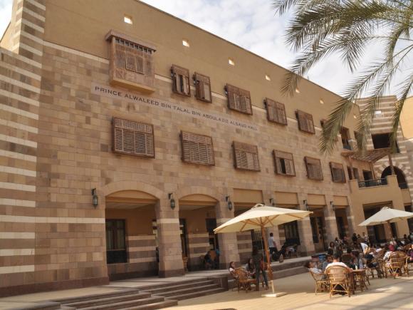 Prince Alwaleed Bin Talal Bin Abdulaziz Al Saud building with students seated in the outdoor courtyard.