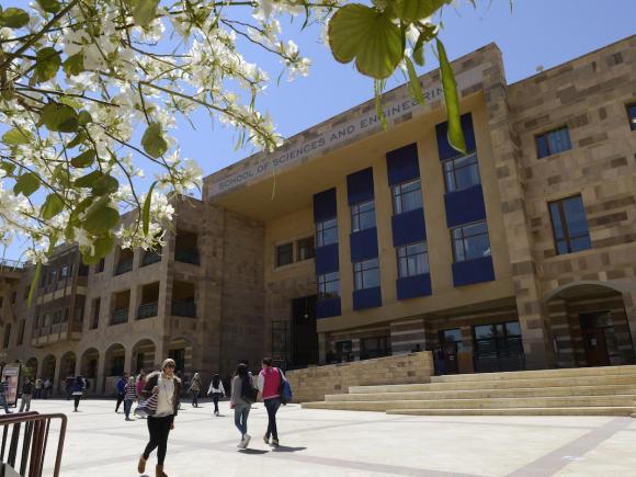 Students walk outside the School of Sciences and Engineering building on AUC&rsquo;s campus.