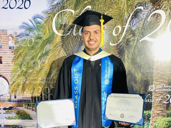 Graduate student EzzEldien Yousef holding his certificate and award at the 2026 commencement