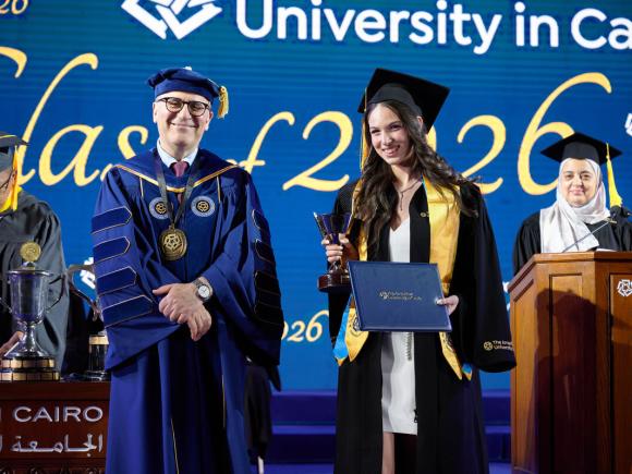 Student Jana Khairy with AUC President receiving an award in commencement  