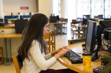A student using a computer in the AUC library