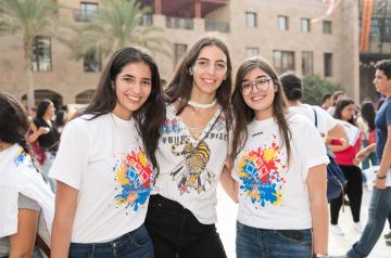 three auc students taking a picture on campus