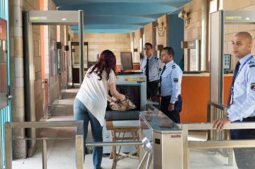 Two AUC security personnel performing a security check.