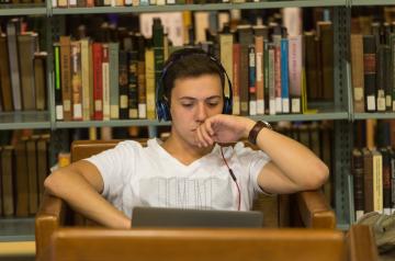 student in library with headphones