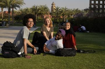 AUC international students sitting in the campus gardens.