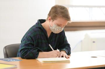 AUC student writing in a copybook