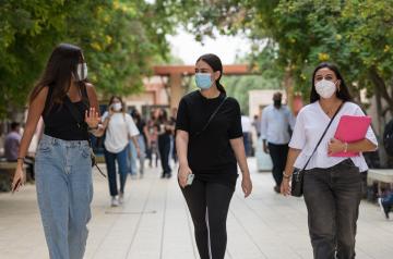 three girls walking on campus