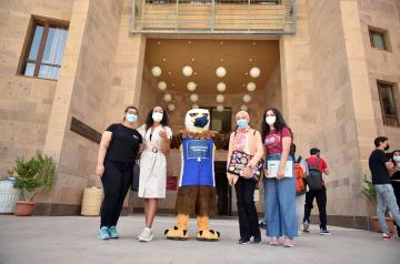 AUC Students on Campus wearing masks with the Mascot